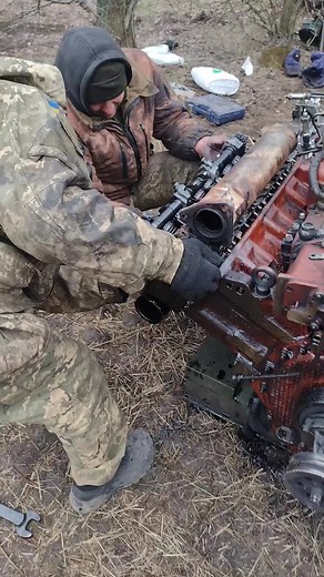 Repairing a Red Engine Block in Camouflage Gear