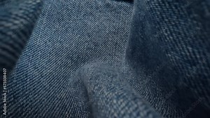 Macro shot blue denim jeans material. Slider dolly extreme close-up of clothing material, camera glides over fabric texture. Seams sewn with yellow threads. Shot with laowa 24mm lens