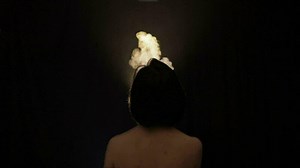 Beautiful, naked woman smoking hookah. Attractive girl smoking flavored tobacco