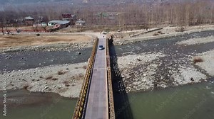 Aerial view of a car driving on a bridge on a river in Pahalgam, India