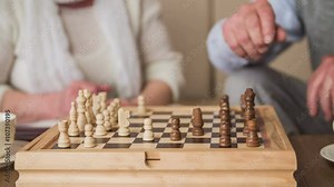 Elderly person move chess figure on board