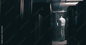 Man, data center and computer for maintenance, system solution and server room coding or cyber security at night. Back of technician with laptop engineering, gdpr software and backup or cables check