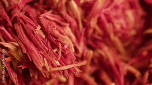 Dried crimson saffron on grey desk close-up macro. Orange red spice for food. Crocus sativus flower saffron
