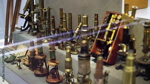 Rack focus to a group of ancient brass microscopes displayed in an optics exhibition