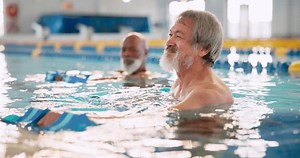 Dumbbell, training and man in swimming pool for exercise, health and strong muscle. Weight, water and aerobics class for senior fitness, physical therapy and rehabilitation of happy group in lesson