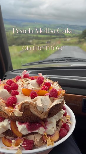 Robin Lucas on Instagram: "Peach Melba Cake Layers of vanilla sponge and meringue (based on the magnificent @nigellalawson recipe), filled with whipped cream, roast raspberries and peaches. Topped with more fresh fruit and honeysuckle blossom. Want a slice? 🧡🩷 #peachmelba #cake #baking #september #rangeroverclassic #lancashire"