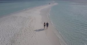 4k Couple Walking on a Beach Filmed with a Drone