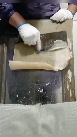 Scraping pig skin for making fried crispy pork skin.