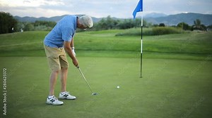 Wide angle shot of a golfer making a long putt! The golfer is playing on a beautiful resort golf course.