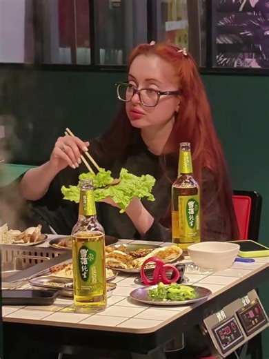 A beautiful Russian woman learned how to eat lettuce wraps with meat in Heihe. #culture #food