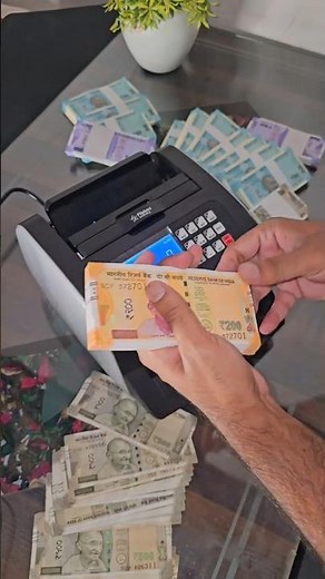 Counting 200-rupee currency notes