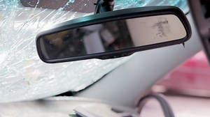 Car interior after an accident with a cracked and broken interior rear view mirror. The wreckage of the interior of a modern car after an accident. Inside the car after a car accident.