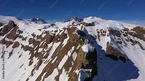Aerial drone footage of the alps mountain above the Anzere ski resort in the alps in canton Valais in Switzerland on a sunny winter day. Shot with a tilt down motion