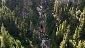Cinematic aerial reveal of Cascada Cailor and the surrounding landscape of the Rodnei Mountains, Romania