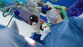 Ophthalmologist performing an eye surgery under the microscope at the...