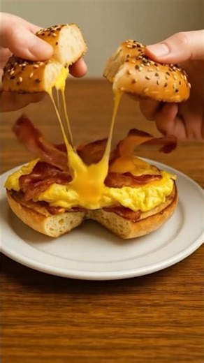 NYC bacon egg and cheese bagel held the right way — bagels near me breakfast near m