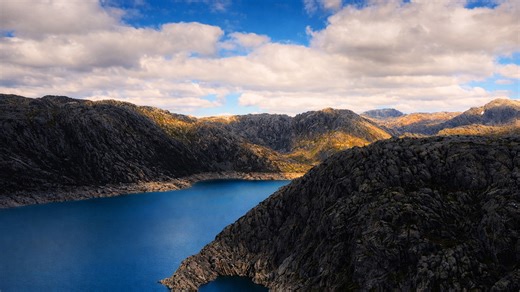 Hidden lake resting silently among rough mountain peaks