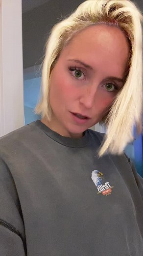 Person Adjusting Hair in Texas Sweatshirt Video