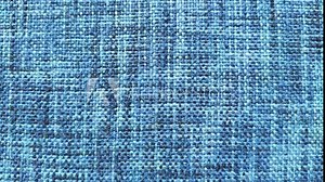 Stop motion loop animation footage of moving blue color cotton denim cloth sheet surface background texture with copy space. Textile industry and fashion business concept. Closeup macro top view.