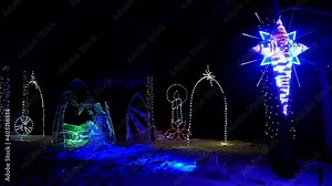Christmas themed Iced Sculpture nativity scene on a bed of snow in a winter evening neon bright LED lights spotlighting an incredible illuminating Star of David framed n candle wheel luminous shinny