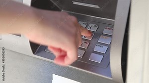 Woman pressing password at ATM machine