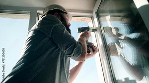 Worker replacing an old window with new plastic window . Apartment renovation