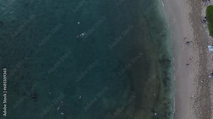 Aerial Kauai Hawaii Poipu Beach tilt up to sunset. Surfing and swimming tourist Hawaiian seascape recreation. Swimming and snorkeling areas, and reef surf. Economy is tourism based.