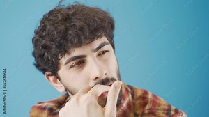 Stressed and worried young man biting his nails. Aggressive and stressed young man biting his nails out of anger or worry. Bad habits.