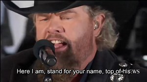 🇺🇸 It was long after the cameras stopped rolling when Toby Keith sat alone at his kitchen table — just him, a folded letter, and a memory that still hurt. The letter came from a young soldier who’d lost his father in the same attack that took Toby’s dad. It only said, “I know you understand.” For a while, Toby just stared at those words. Then he picked up his guitar. And that night, “Courtesy of the Red, White and Blue” was born — not out of anger, but out of love. A deep, aching kind of love 