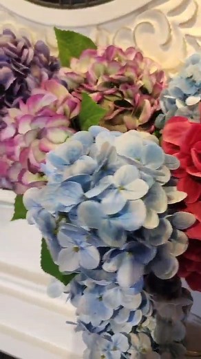 Breathe new life into your mantel with soft pastels, blooming florals, and a fresh piece of art. Pink, blue, and purple hues bring the season in with charm and color. 🌸💙💜 #SpringDecor #FireplaceStyling #MantelMagic | Fabulous Gifts and Home Decor