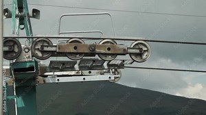 Mountain ski cable lift mechanism in action. Rollers and bearings rotating fast pulling cable of chairlift