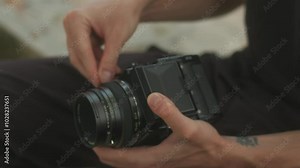 Setting up a film camera with a roll of film in hand to capture stunning moments creatively