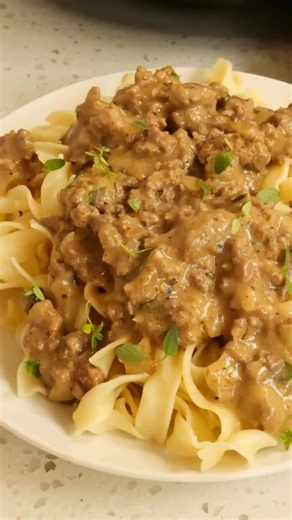 This tasty Hamburger Gravy Recipe brings ground beef together with garlic and onions in a creamy brown gravy seasoned with thyme, parsley, and nutmeg. | Savory Splash