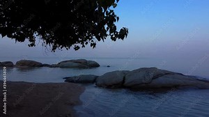 Fly back from stunning dawn ocean and sky over beach rock along beach