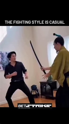 PrankInTheDark on Instagram: "The video features a humorous confrontation between two men. One is dressed in modern attire (a black button-down and slacks), while the other is dressed as a traditional Japanese samurai, complete with a kimono and a distinct topknot (chonmage). ​The scene starts with the samurai drawing a sword, but the "fight" quickly devolves into absurdity. Instead of a sword fight, the man in black uses a series of comical slaps and rapid-fire movements—at one point even using