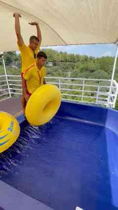 Lifeguard jumps headfirst down a huge water slide!