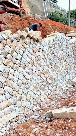 Building a sturdy retaining wall with precisely stacked natural stone blocks