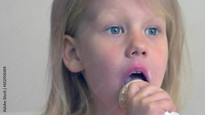 focus on little beautiful girl eats the ice cream getting her mouth dirty