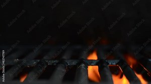 Orange flames flare underneath a grill (Looping)