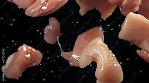 Pieces of raw chicken fly up and fall down. Filmed on a high-speed camera at 1000 fps. High quality FullHD footage