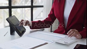 Portrait of a woman working on a tablet computer in a modern office. Make an account analysis report. real estate investment information financial and tax system concepts.