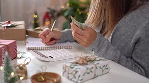 Girl counting US Dollar bills, using calculator, and writing expenses. Woman doing budget, estimating money balance for shopping spree. Female accountant paying taxes. Girl counting Christmas gifts.