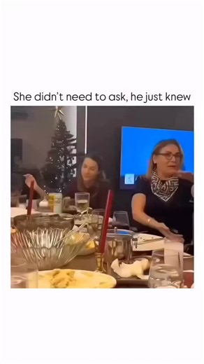 Stranger learn on Instagram: "This video captures a playful and heartwarming moment during a dinner gathering, set against a cozy backdrop featuring a Christmas tree. The scene focuses on a young woman sitting at a table filled with glasses, plates of food, and candles. To her right, another woman is engaged in conversation, but the main subject is looking down, appearing slightly reserved or distracted by the activity around her. As the video progresses, a person off-camera uses a remote contro