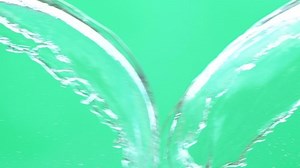 Slow motion of water spash with drops over green screen chroma key background