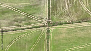 Aerial view of Tractor Prepare the soil crops at farm field. Agricultural activity.Tractor drives across large field making special beds for sowing seeds into purified soil. Agricultural vehicle worki