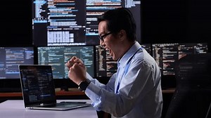 clip-1099212563-side-view-asian-male-programmer-celebrating-succeed