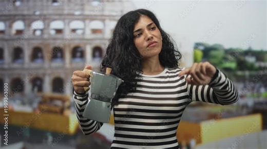 Woman holding a moka pot points finger toward a roman coliseum building while standing in front, mid gesture; curiosity.