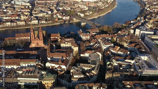 Basel, Switzerland: Cinematic aerial drone footage of Basel old town with the gothic cathedral, the Munster, along the Rhine river in Switzerland with a revealing tilt up motion.