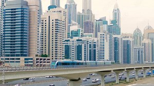 The subway train rides among the glass skyscrapers in Dubai, UAE