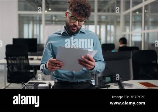 Thoughtful puzzled Arabian business man writing in papers analyzing report thinking ethnic businessman think review documents specialist male deciding idea confused paperwork write standing at office Stock Video Footage - Alamy